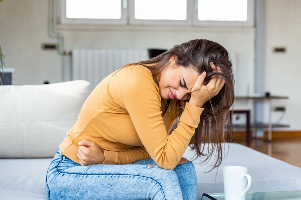 Young sick woman with hands holding pressing her crotch lower abdomen