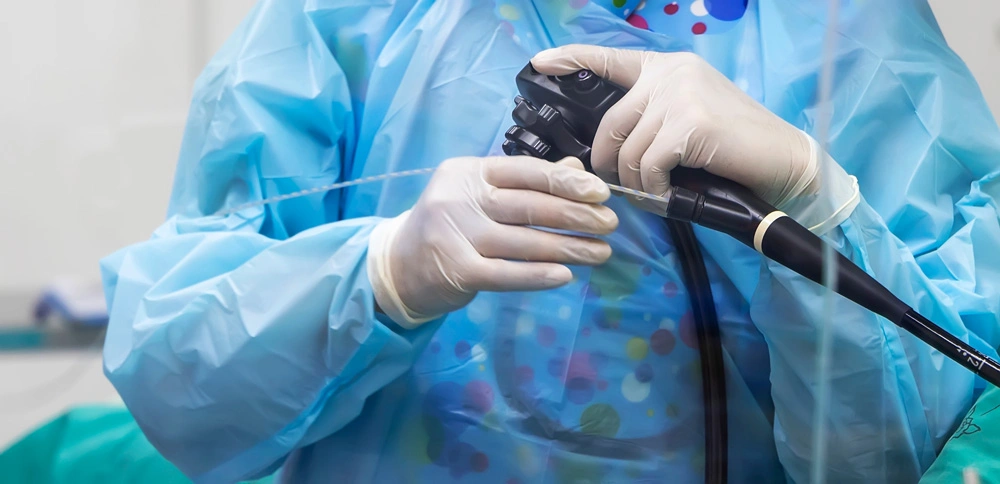 Close up photo of surgeon 's hands inside modern operating room in blue surgical gown.