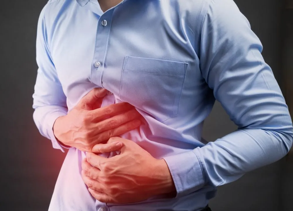 Man touching his stomach for heartburn pain