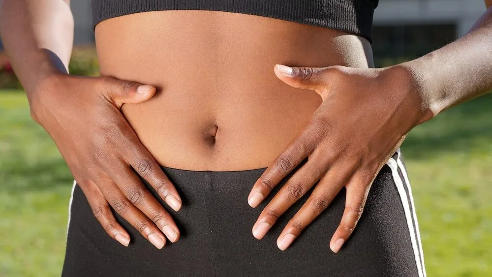 A woman with her hands on her stomach