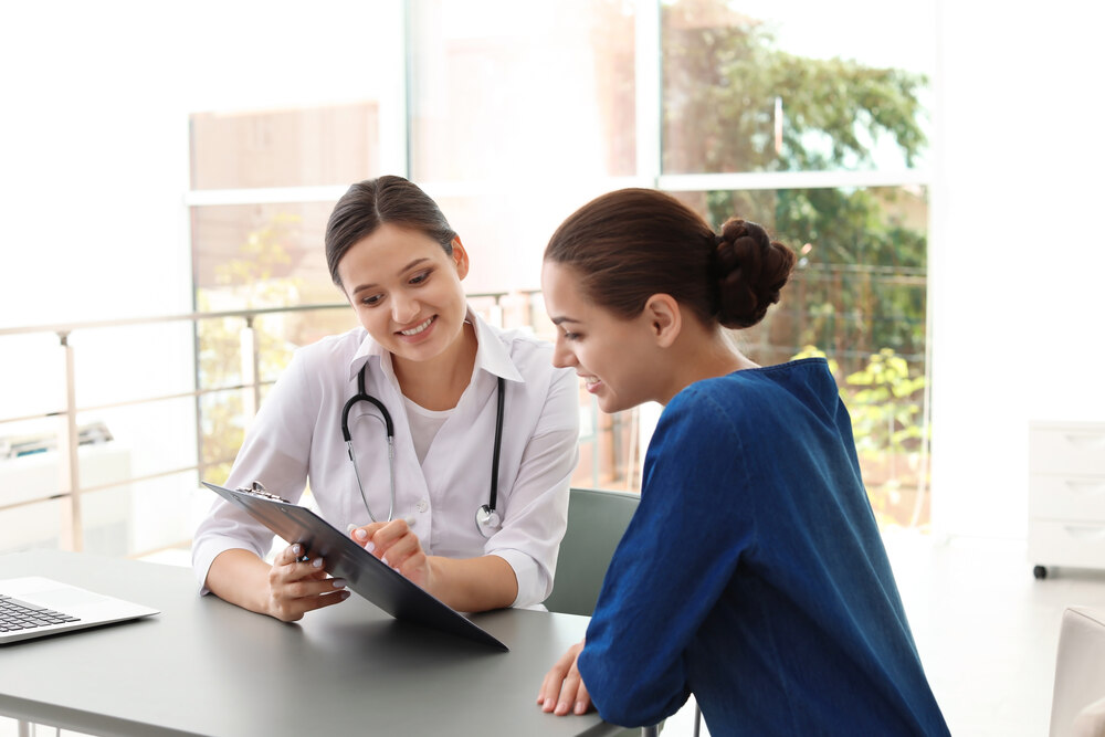 Young doctor consulting patient in modern hospital