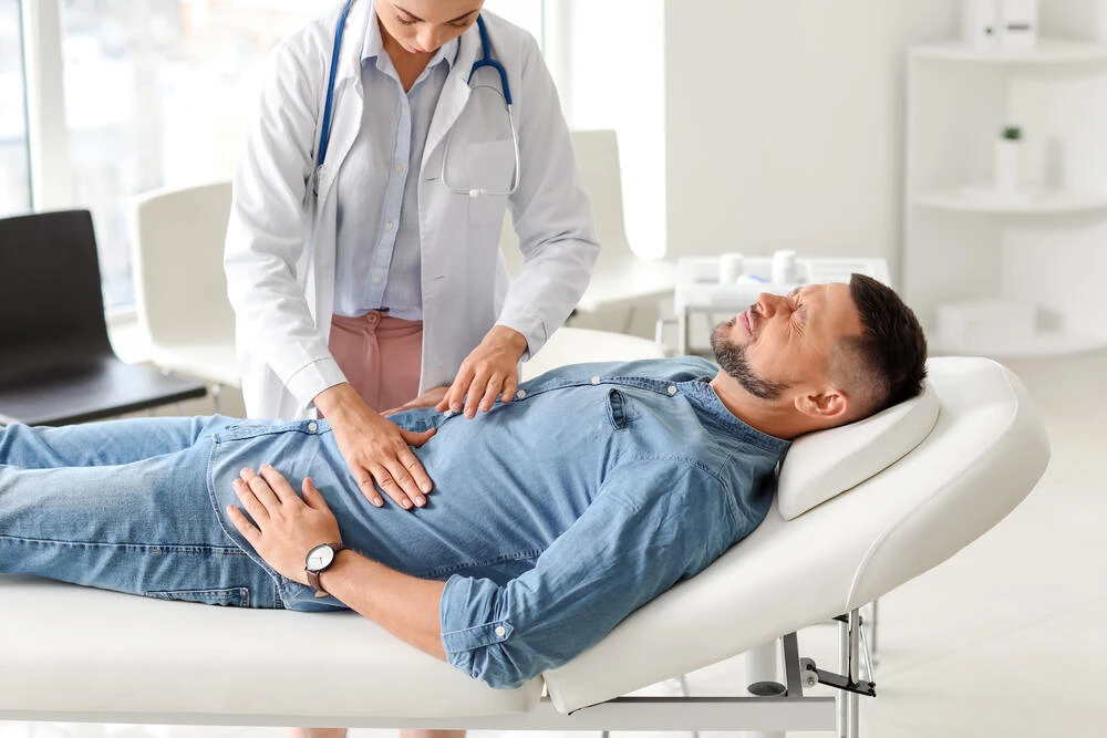 Gastroenterologist examining man in clinic