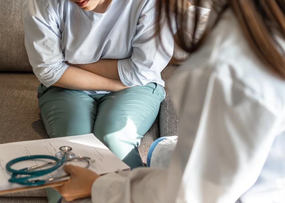 Abdominal pain patient woman having medical exam with doctor