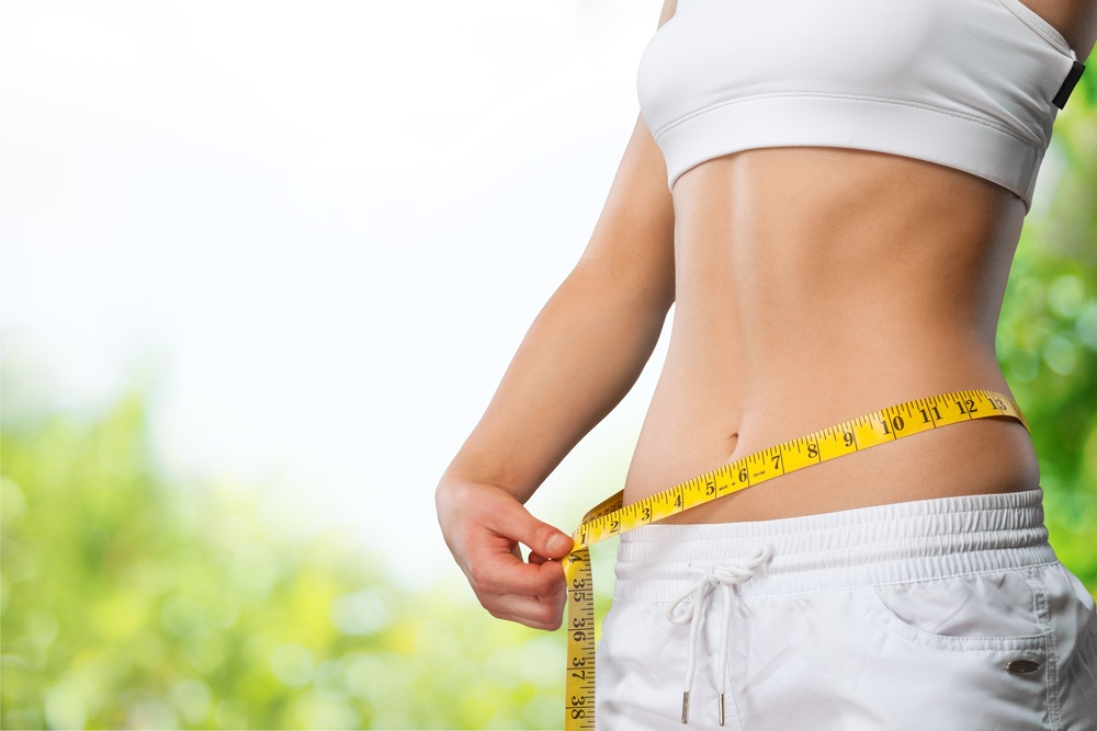 Woman holding a measuring tape around her waist