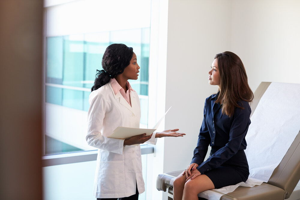 Female Doctor Meeting With Patient In Exam Room