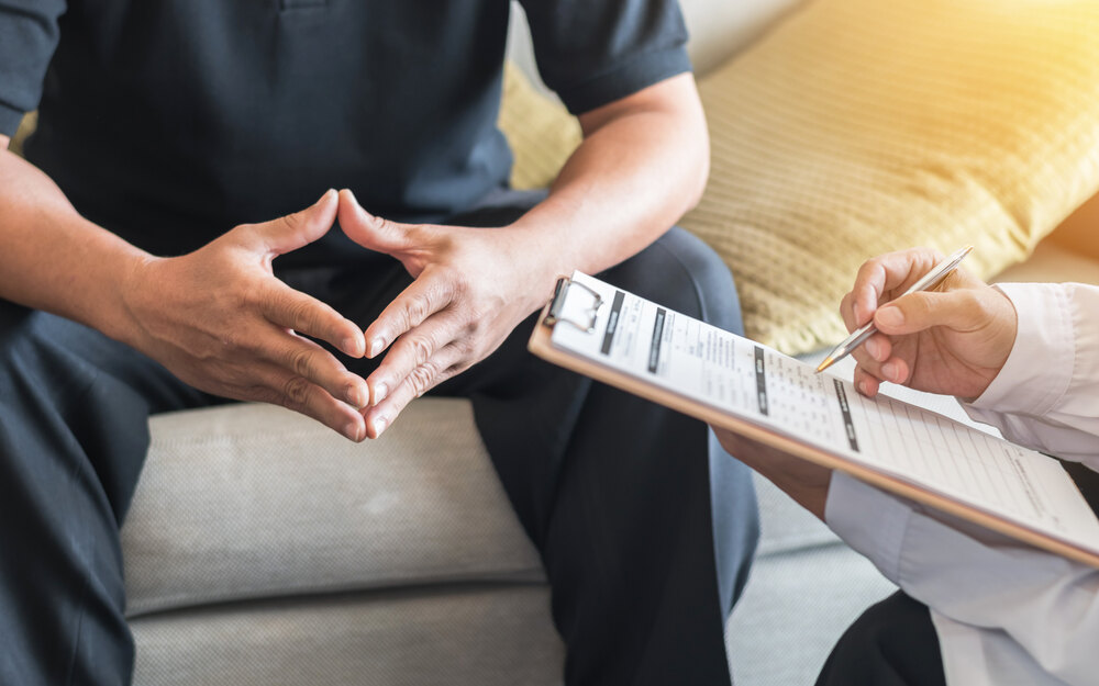 Male patient having consultation with doctor or psychiatrist who working on diagnostic examination on men's health disease