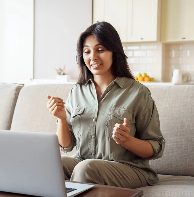 Young adult woman talking by video conference call using laptop computer work from home office