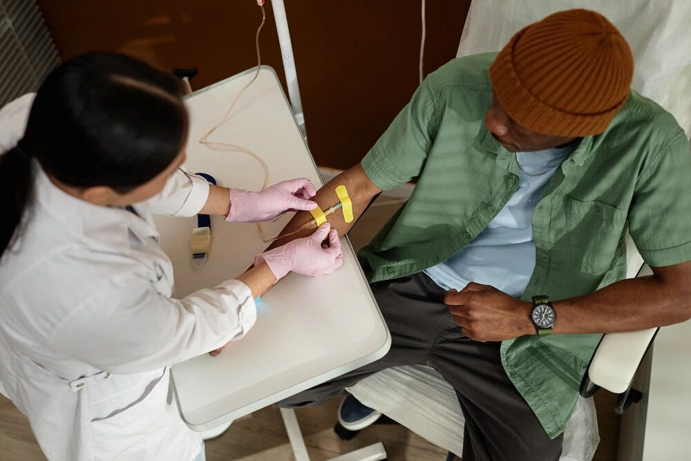 Top view portrait of female doctor preparing patient for IV infusion in procedure room at clinic