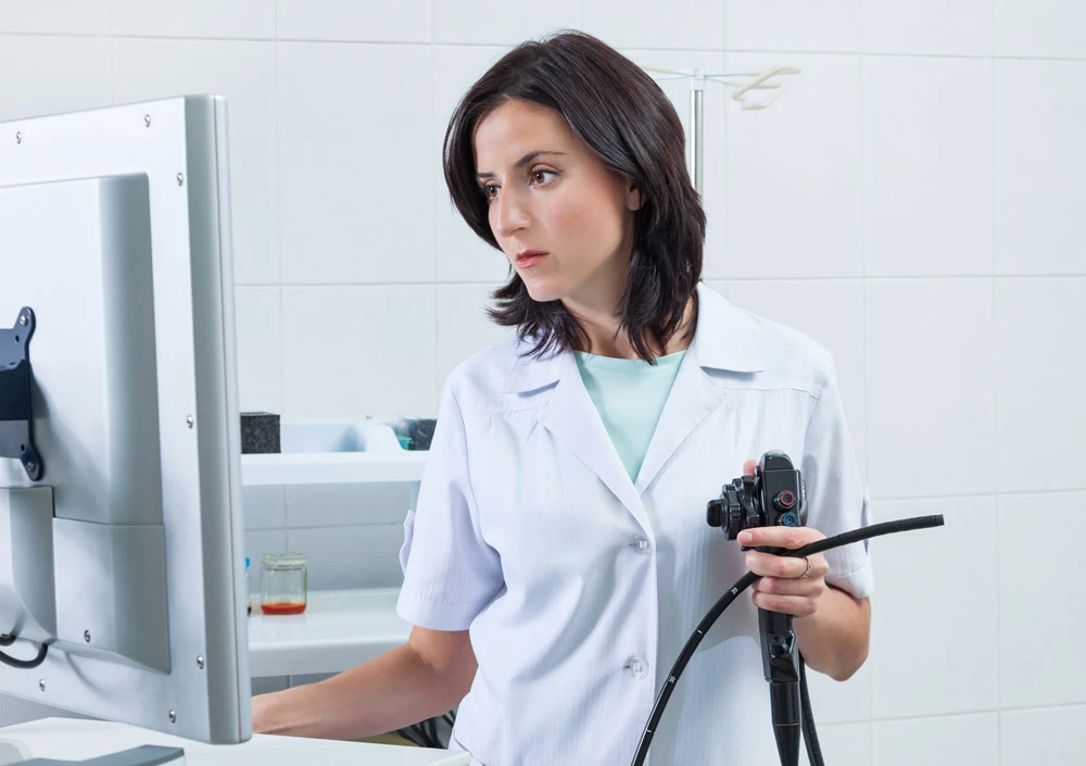 Young brunette doctor with an endoscope in his hands
