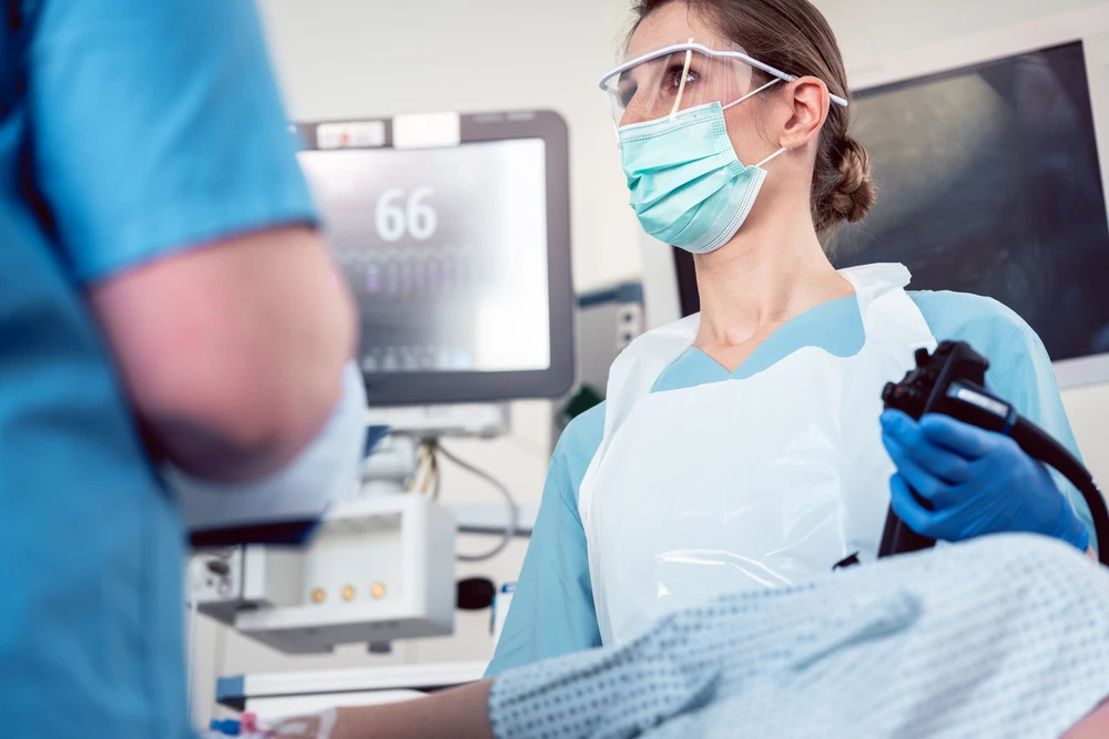 Internal specialist doctor operating endoscope in colonoscopy procedure