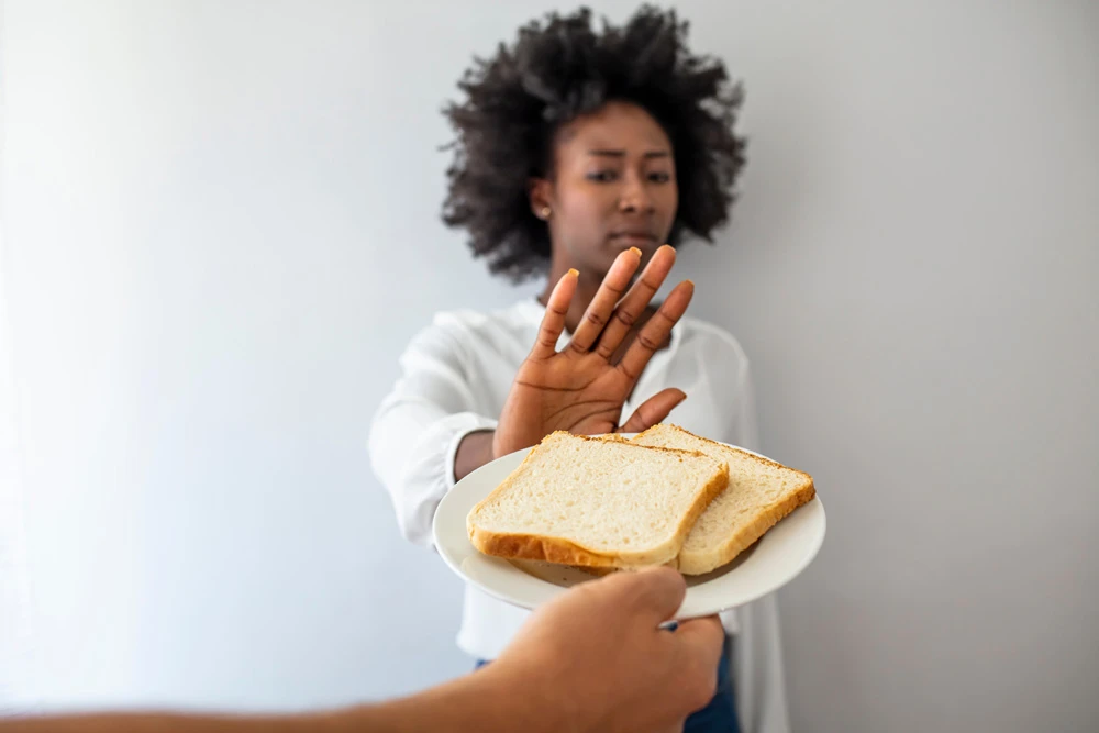 Young woman on gluten free diet is saying no thanks to toast.