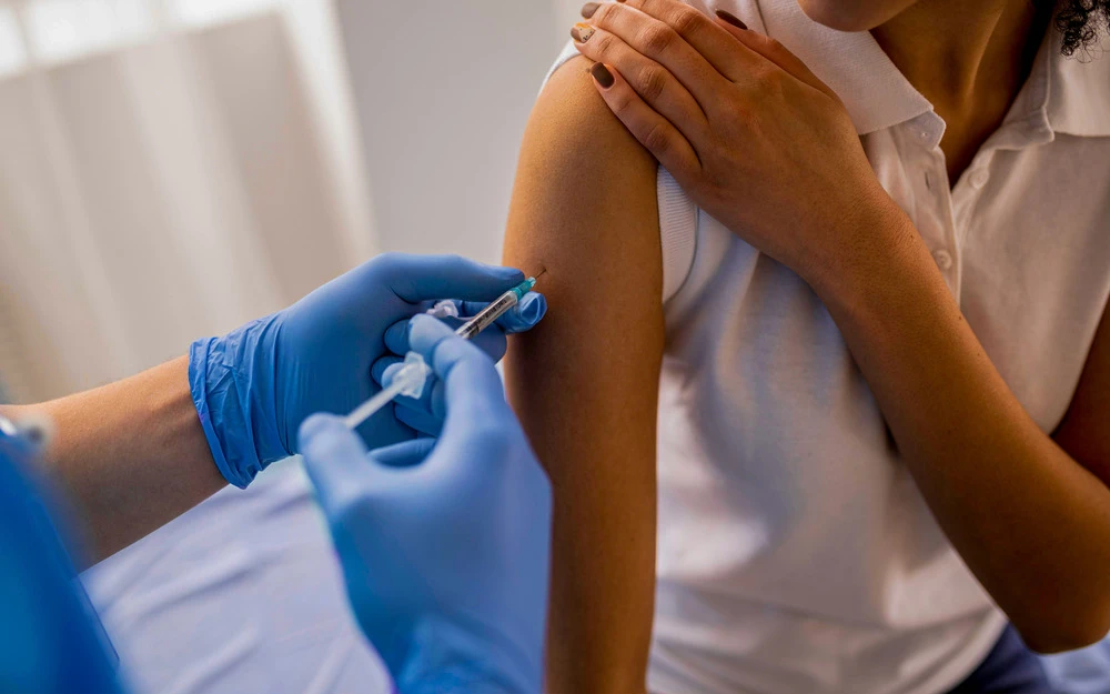 Doctor injecting vaccine to patient