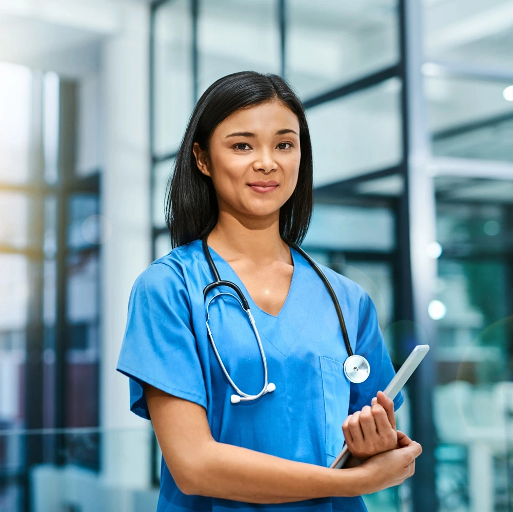 Portrait of a young nurse standing in a hospital.