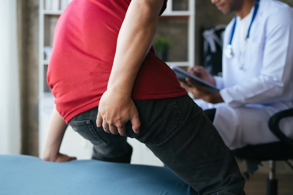 Man seeing doctor with hemorrhoids symptoms