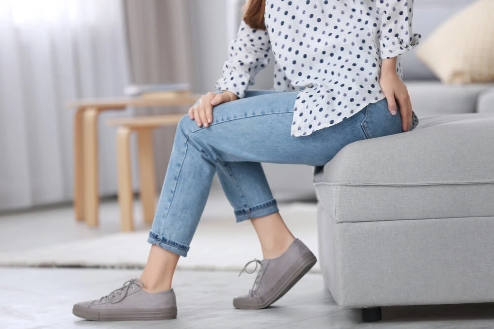 Young woman suffering from hemorrhoid at home